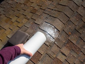 Homeowner performing summer roof maintenance. Contact your local Portland roofing contractor for professional assistance!