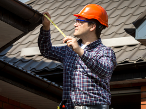 A professional roofing contractor inspecting a roof for energy performance issues in Des Moines.