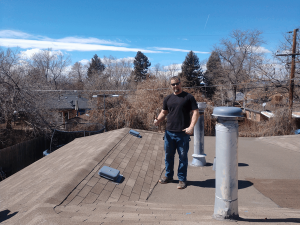 Clive roofers inspecting a roof for ice dam prevention measures.