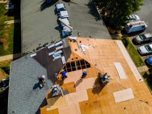 Action Roofing team winterizing a roof in Des Moines, equipped with safety harnesses.