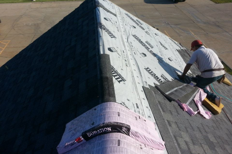 professional roofer repairs a damaged roof with new Owens Corning Duration shingles in Newton, Iowa